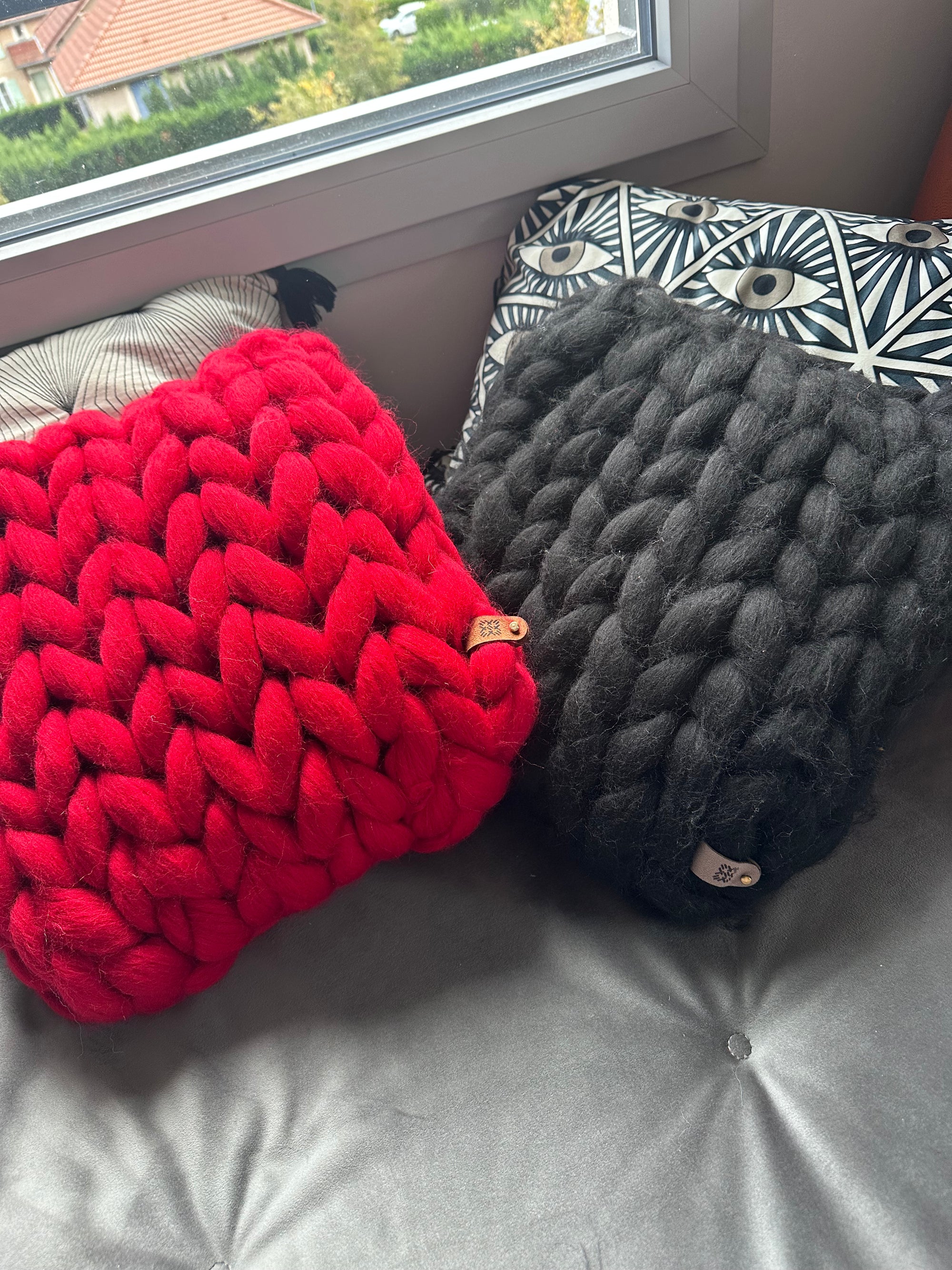 Coussin 40x40 en laine mérinos rouge-noir, maille généreuse. Confort et élégance pour une déco chaleureuse