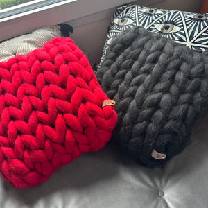 Coussin 40x40 en laine mérinos rouge-noir, maille généreuse. Confort et élégance pour une déco chaleureuse