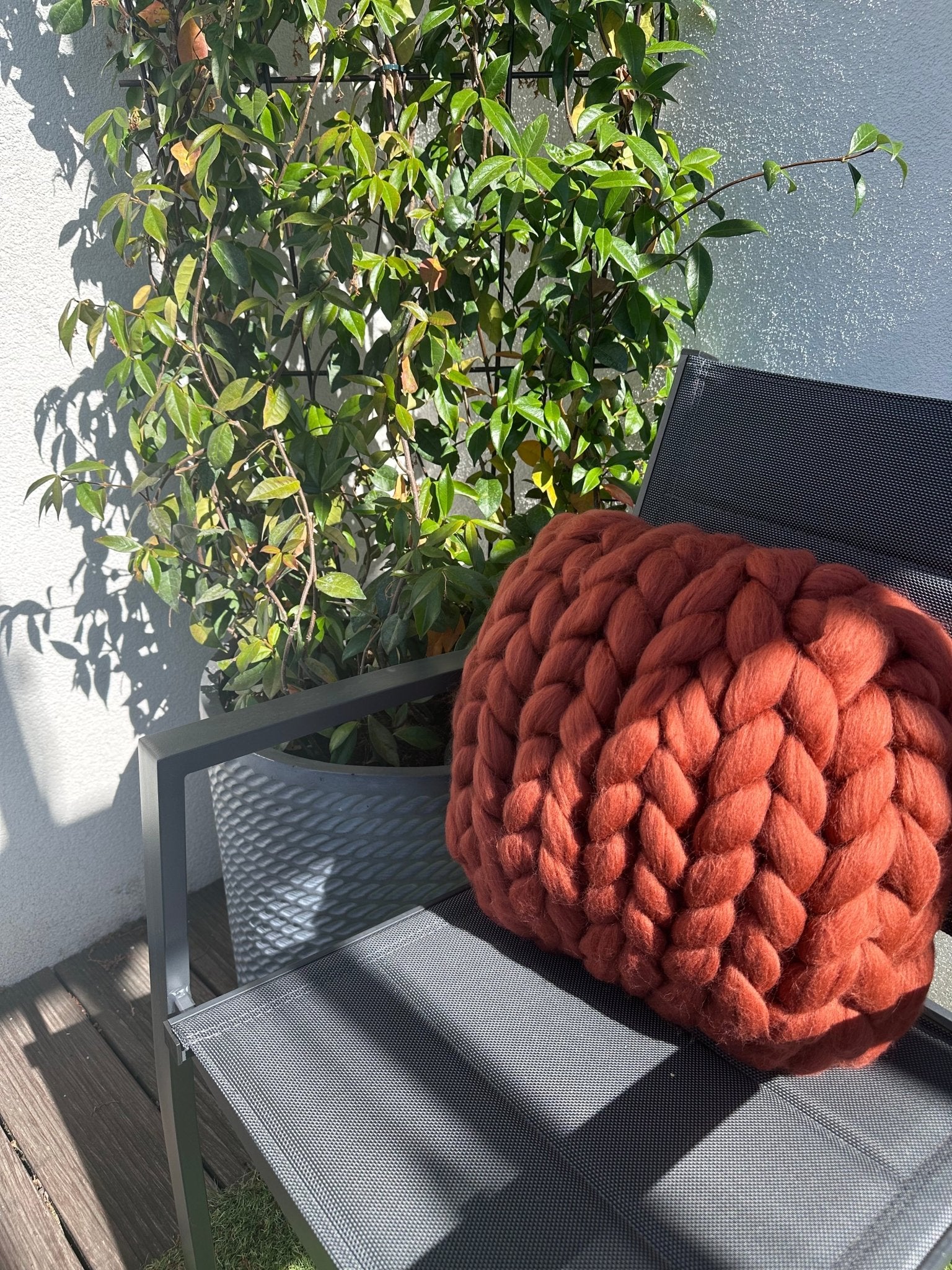 Créez un espace chaleureux et élégant avec ce coussin en laine mérinos à grosse maille de 40x40 cm, d'une superbe teinte terracotta