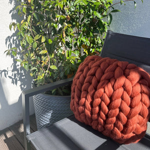 Créez un espace chaleureux et élégant avec ce coussin en laine mérinos à grosse maille de 40x40 cm, d'une superbe teinte terracotta