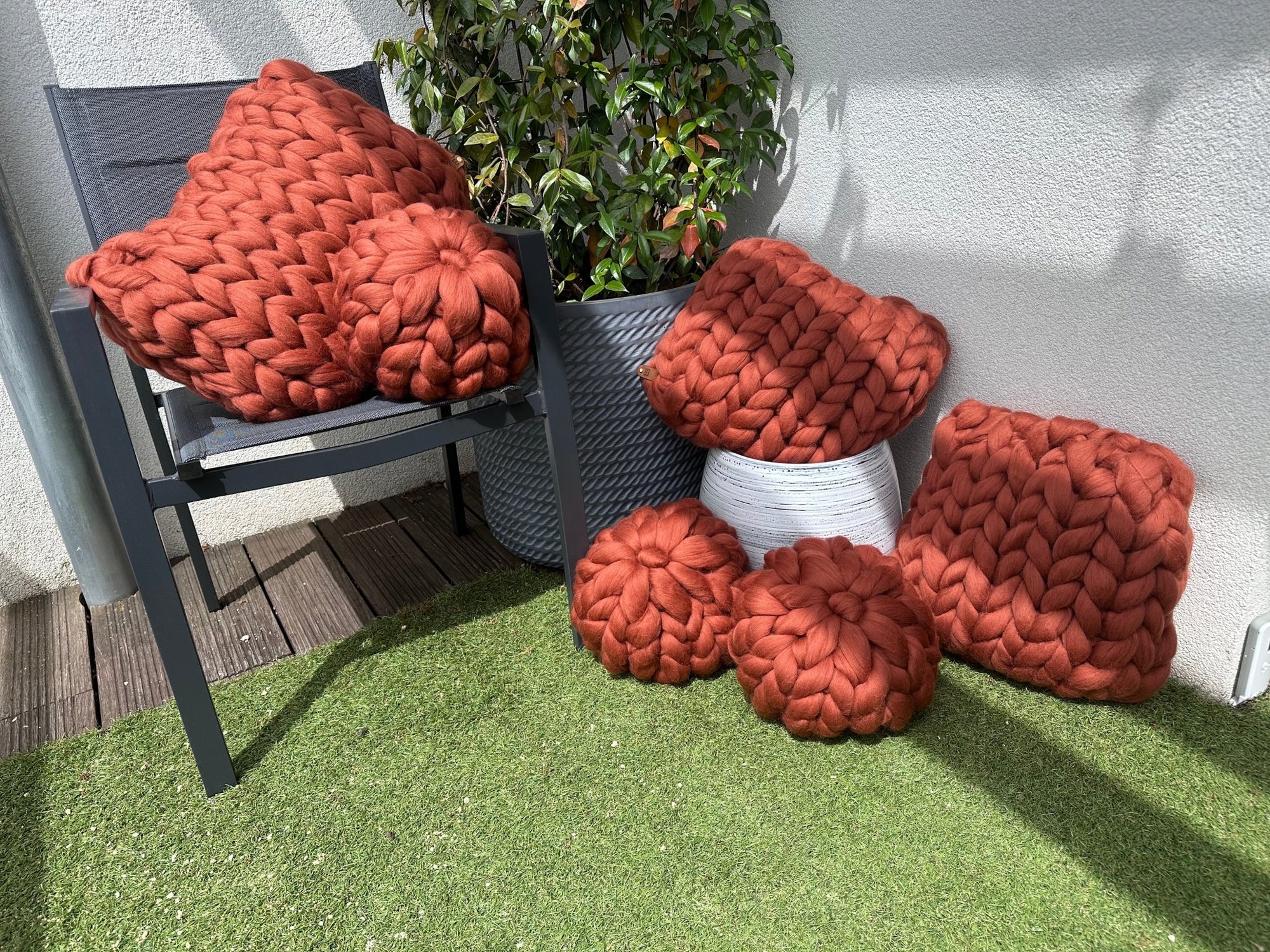 Apportez chaleur et raffinement à votre espace avec ce coussin en laine mérinos à grosse maille de 40x40 cm, dans une superbe nuance terracotta